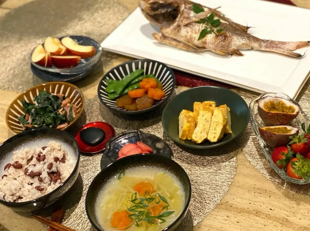 焼き鯛や卵焼き、赤飯、煮物が並ぶ食卓
